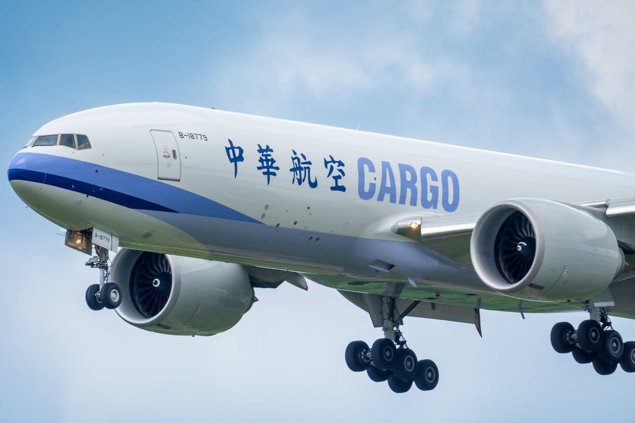 A large cargo airplane approaches landing under a clear sky.